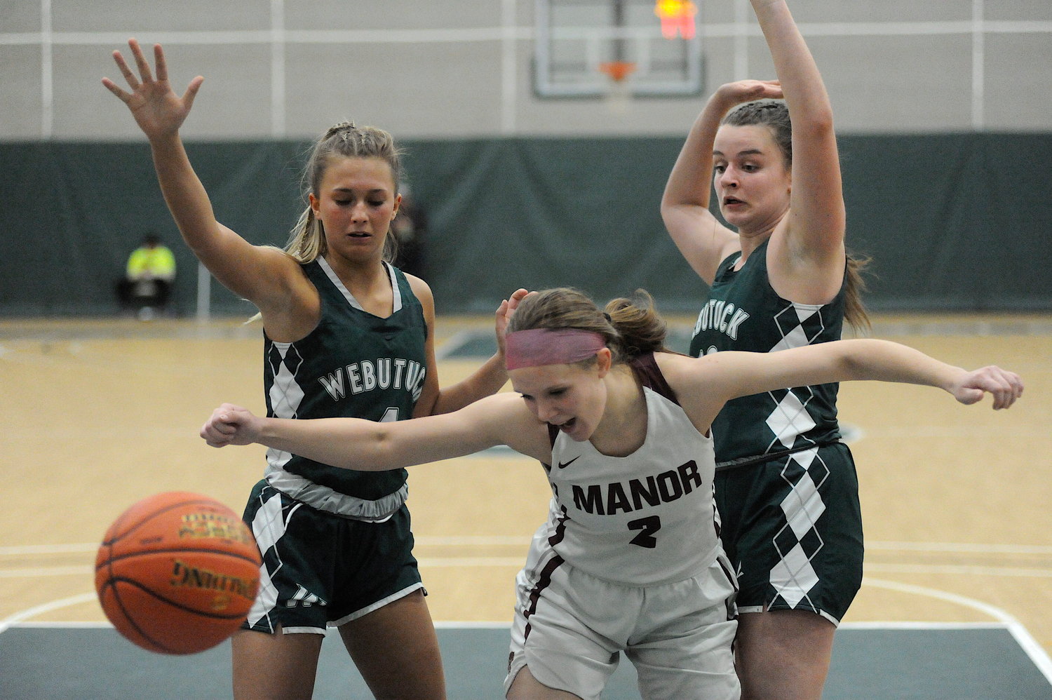 Just out of reach. Manor’s Mackenzie Carlson desperately   tries to reel in a pass headed for no man’s land, against Webutuck defenders Johanna Voight and Riley Thirlwall.